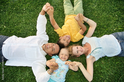 family lying on a grass