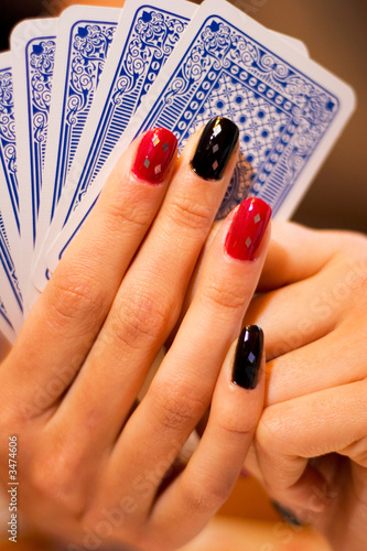 Canvas-taulu Manicured woman's fingers holding a card hand