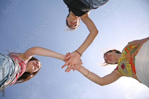 Three girlfriends have connected hands photo