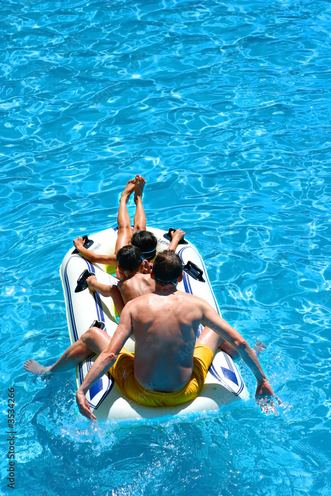 Father and his children on a rubber dinghy, down the lazy river 