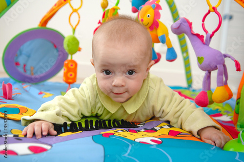 bébé en train de jouer sur un tapis d eveil photo