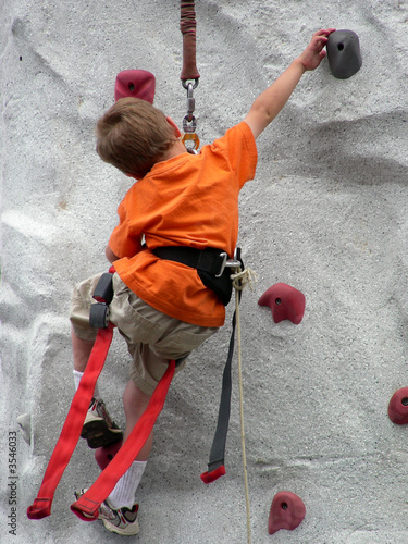 Young climber reaching for the next hand hold