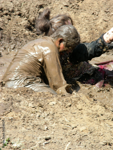 Male and female competitors in a mud wrestling competition