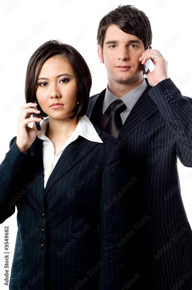 Two young business people with mobile phones on white background Two young business people with mobile phones on white background