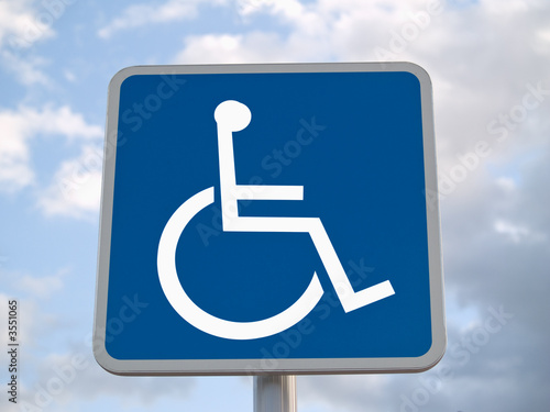 Standard disabled sign with clouds in the background
