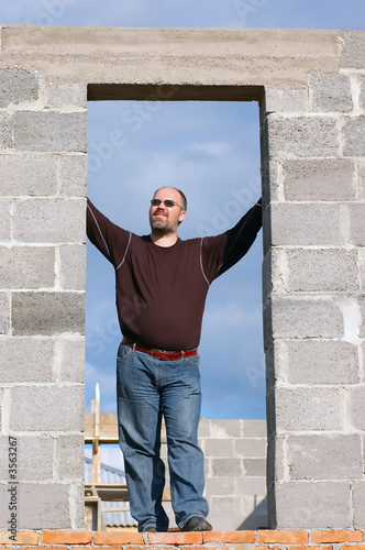 Man standing on the base of own building house