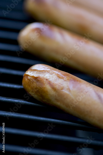 summer bbq  hotdogs on the grill  shallow depth of view 
