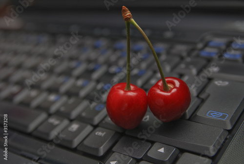 fresh cherry on laptop keyboard photo