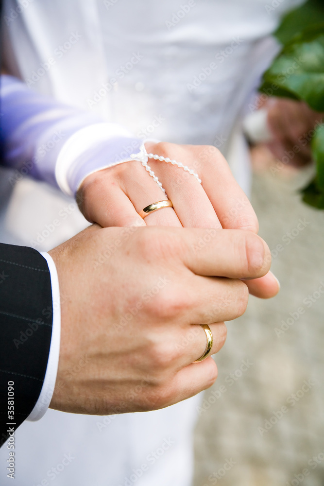 two lover's hands just after marriage ceremony