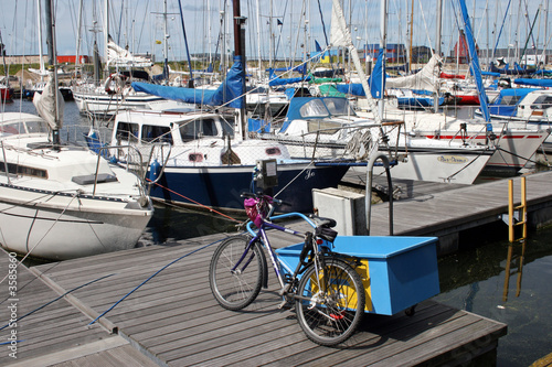 Sailingships in a harbour with a bike on the dock