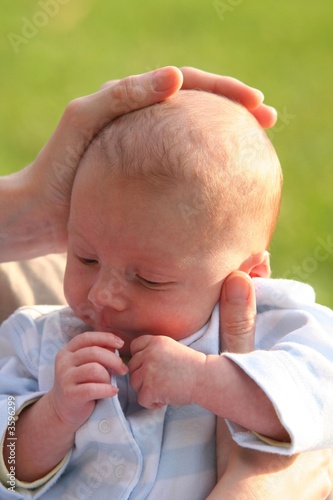 Bébé d'un mois avec la main de sa mère sur la tête