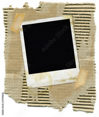 Ripped corrugated cardboard with polaroid and tape.