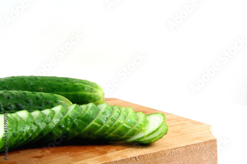 cucumbers on a wooden plate isolated on white