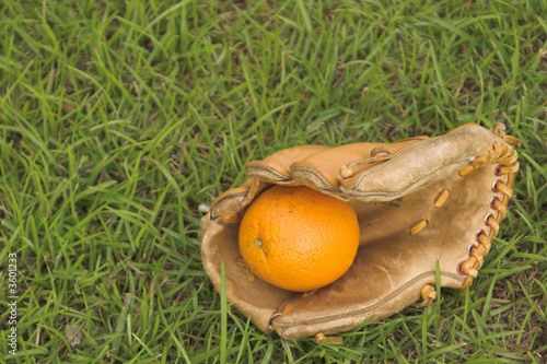 A delicious orange in a baseball glove. photo