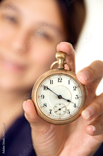 Woman holding up a pocket watch - focus on watch
