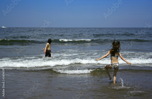 Children playing running to the ocean
