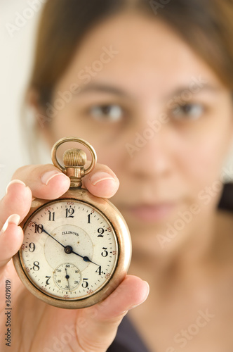 Woman holding up a pocket watch - focus on watch