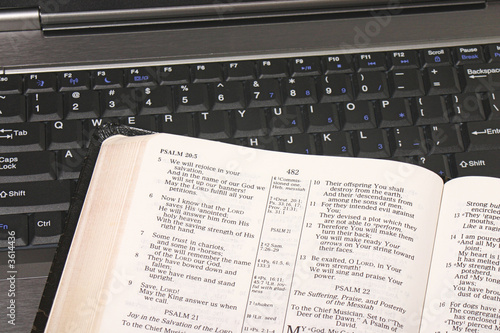 Open Bible on keyboard of laptop