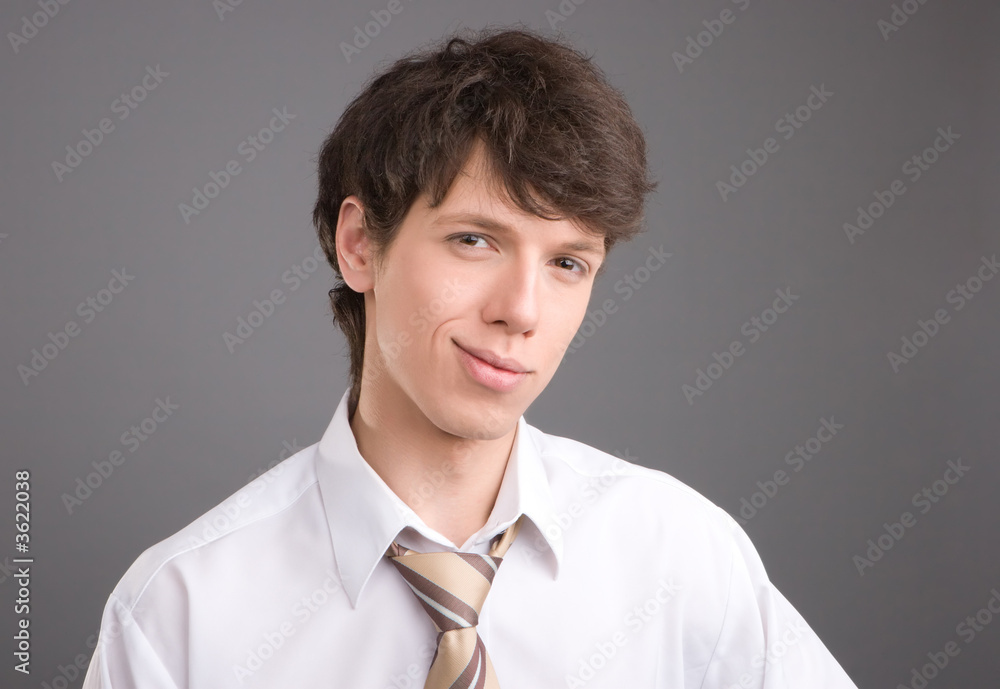 Young businessman friendly smiling portrait isolated on gray Young businessman friendly smiling portrait isolated on gray