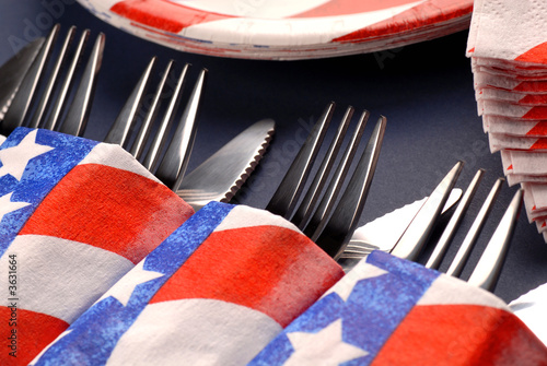 Several knives and forks in a 4th of July table setting