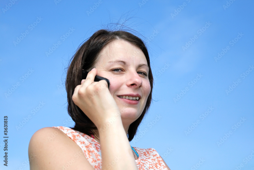 The girl with phone on the sky background