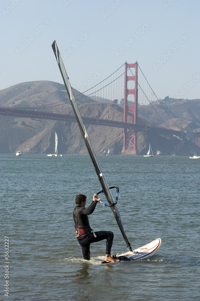 Naklejka premium Windsurfer with Golden Gate boarding