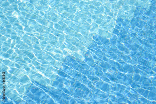 blue water of swimming pool at sunny day .
