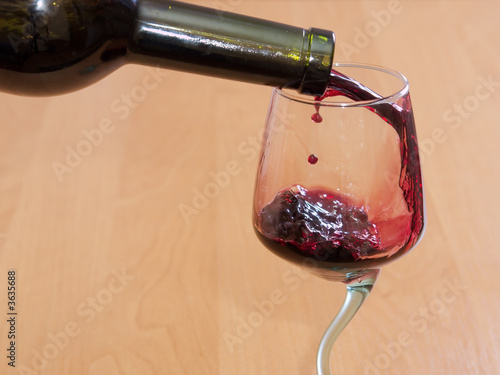 The red wine flowing from a bottle in a glass
