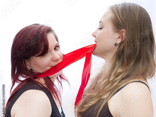 Two girls pulling a red tape
