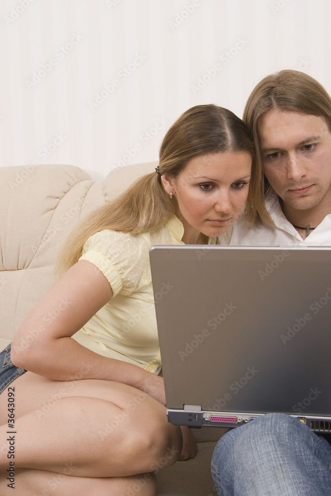 young couple in front of a laptop computer young couple in front of a laptop computer