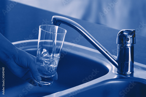 Pouring Fresh Tap Water Into a Glass. Shallow DOF. Focus on Tap.