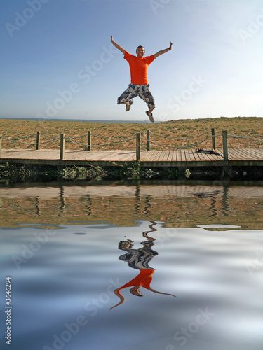 boy jumping to a lake