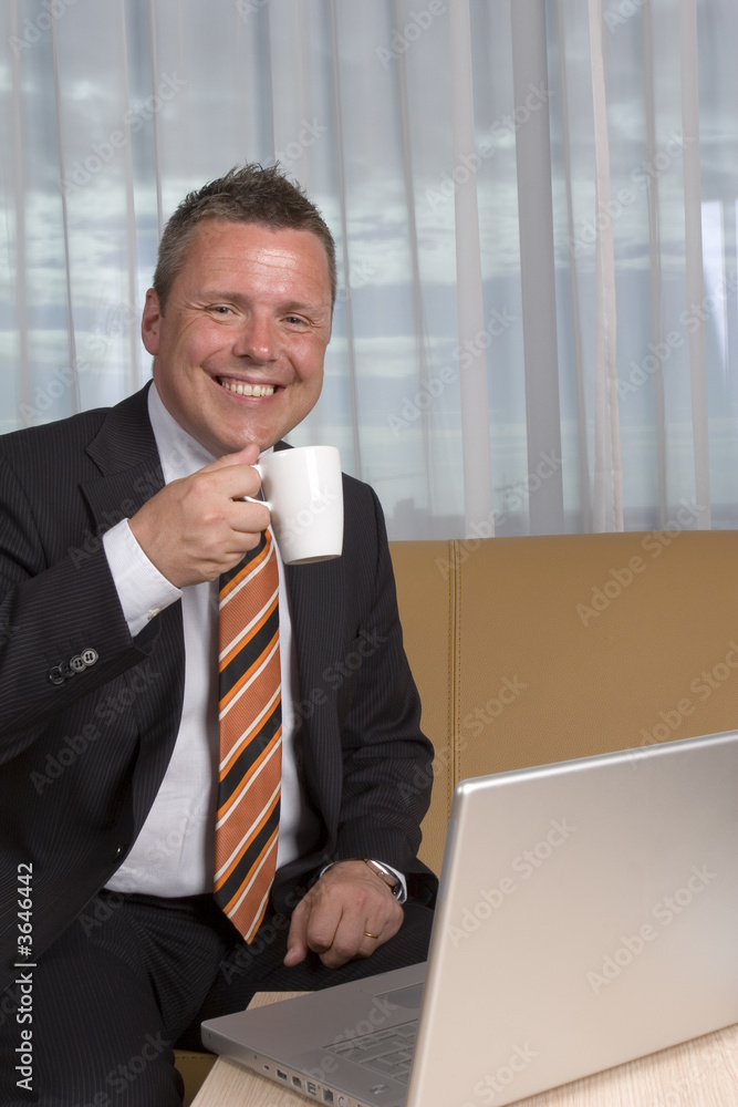 Businessman smiling at camera drinking coffee Businessman smiling at camera drinking coffee