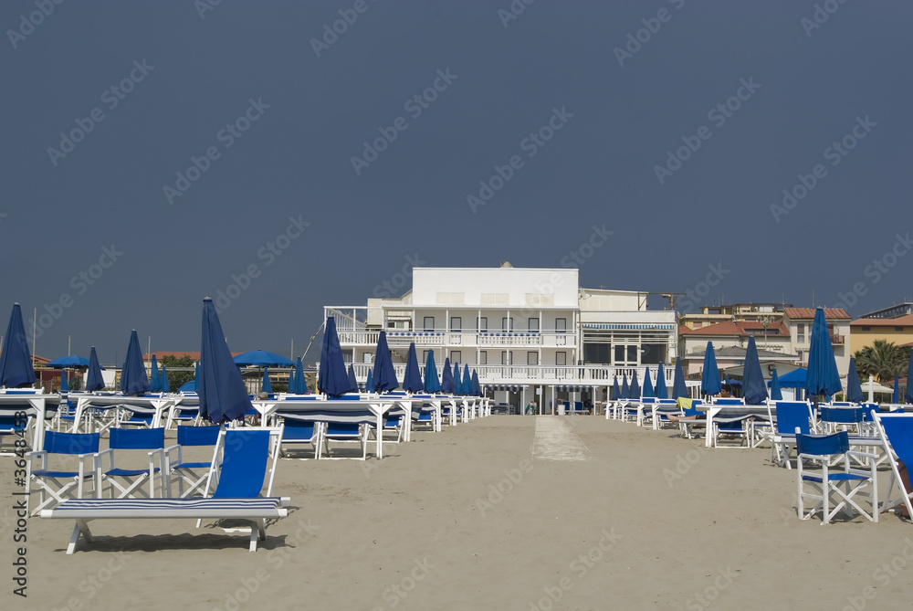 Umbellas and seats in a private beach of tuscany Umbellas and seats in a private beach of tuscany