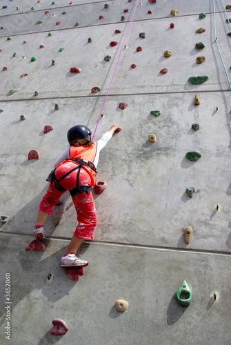 Youngster's effort in climbing a wall to reach the top.