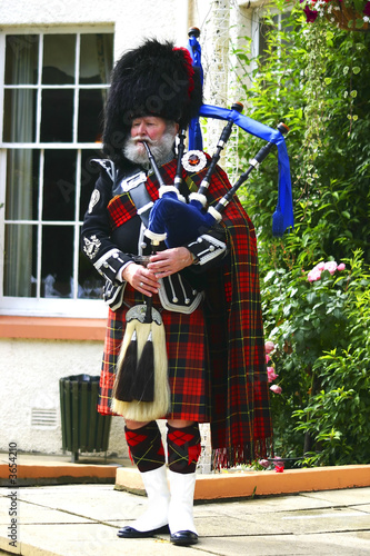 Photo A Scottish bagpiper in full highland kilt dress and beard