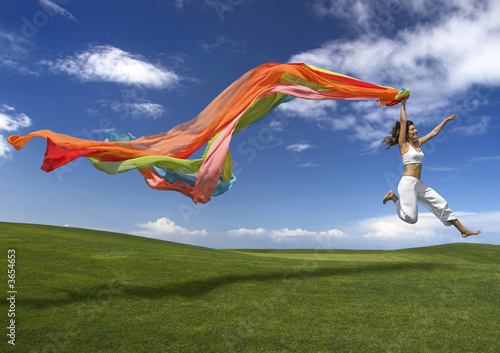 Young beautiful woman jumping with a scarf