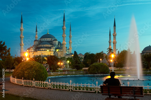 man sitting opposite blue mosque in istanbul in the evening