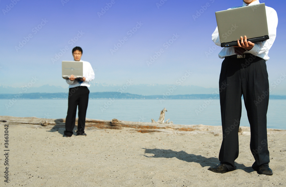 Two businessmen working together at the beach Two businessmen working together at the beach