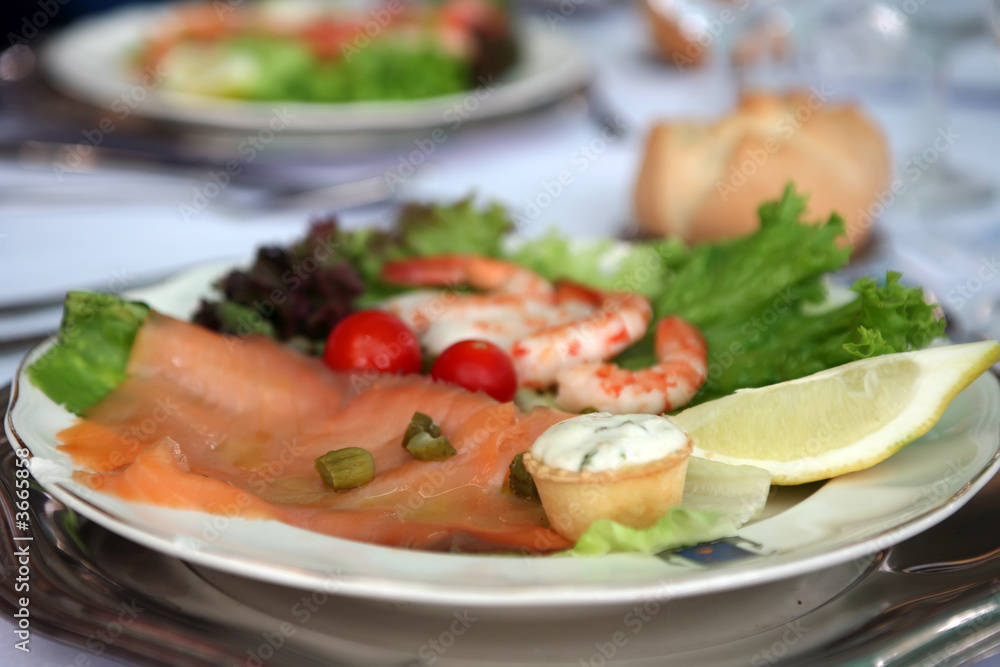 smoked salmon salad on white platter with cullin sauce