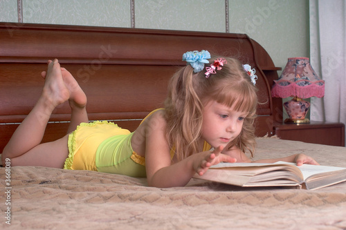 The girl reads the book on a bed 42k photo