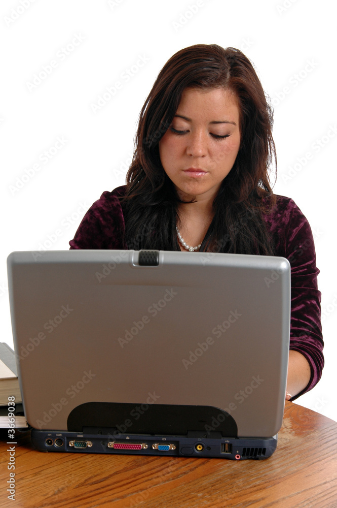 A young woman studying on a laptop computer