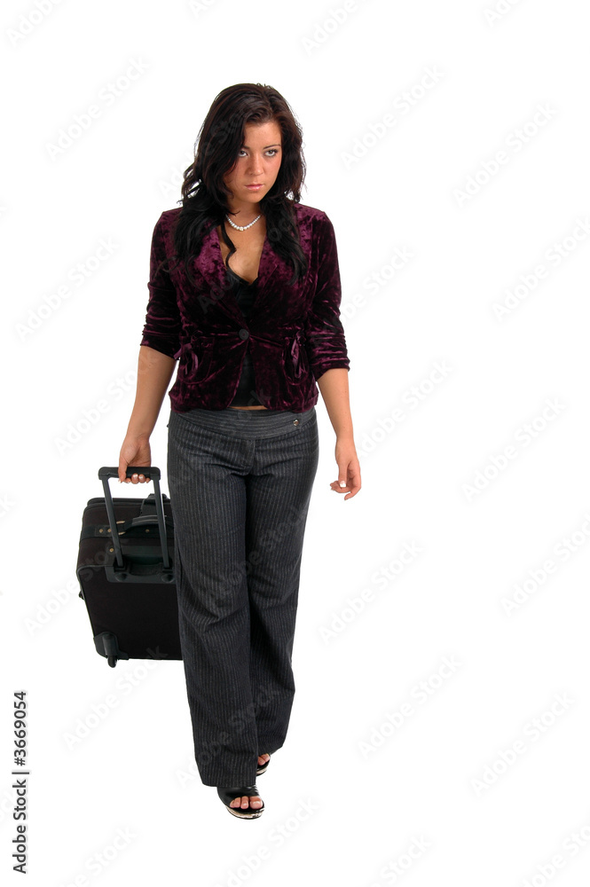 A young woman walking pulling a suitcase A young woman walking pulling a suitcase