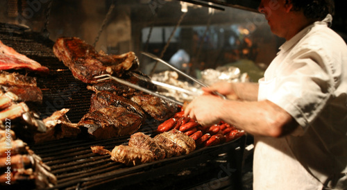 Argentinian chef cooking meat in the restaurant photo