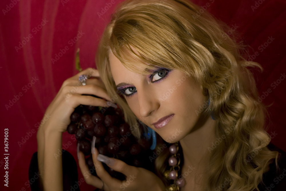 Fototapeta premium young beautiful blond girl with grapes