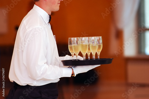 waiter with dish of vine glasses photo