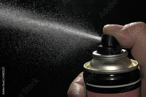 Pulverizing liquid with spray can photo