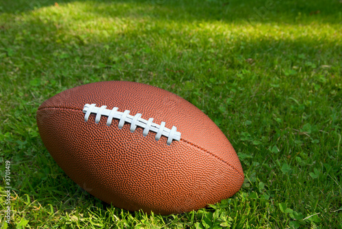 American football isolated on top of a grass background