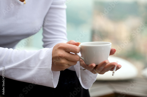 young white woman holding a coffee cup