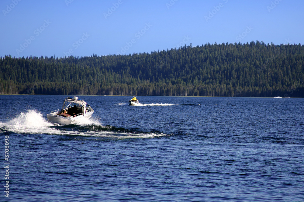 Fototapeta premium Motor Boats Moving Across the Lake in the Mountains